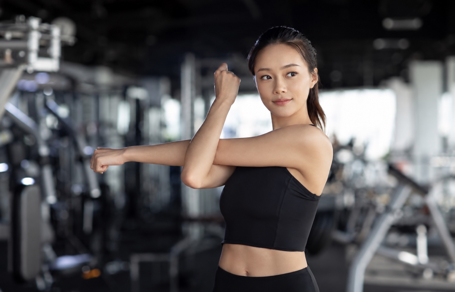 黒いウェアでストレッチする女性のトレーニングイメージ
